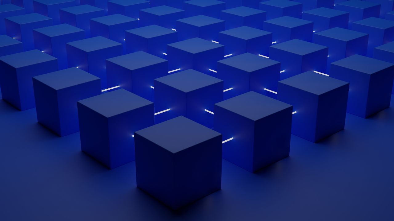 A grid of uniform, matte navy-blue cubes, subtly lit from within by pale-blue lines running through the centers, creating a sense of depth and order;  the scene is entirely composed of these cubes on a flat, deep-navy blue background.